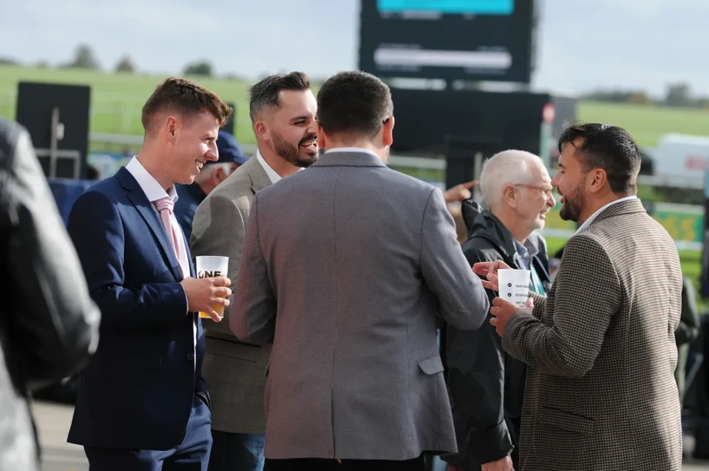 visitors at racecourse drinking from reusable cups